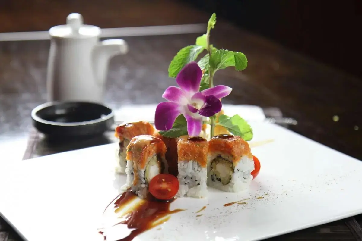 Oriental-Palace-Chinese-Restaurant-Fire-Phoenix-Roll-Castaic Sushi roll with spicy topping, garnished with orchid and cherry tomato, at Oriental Palace, a Asian Restaurant in Lawnside